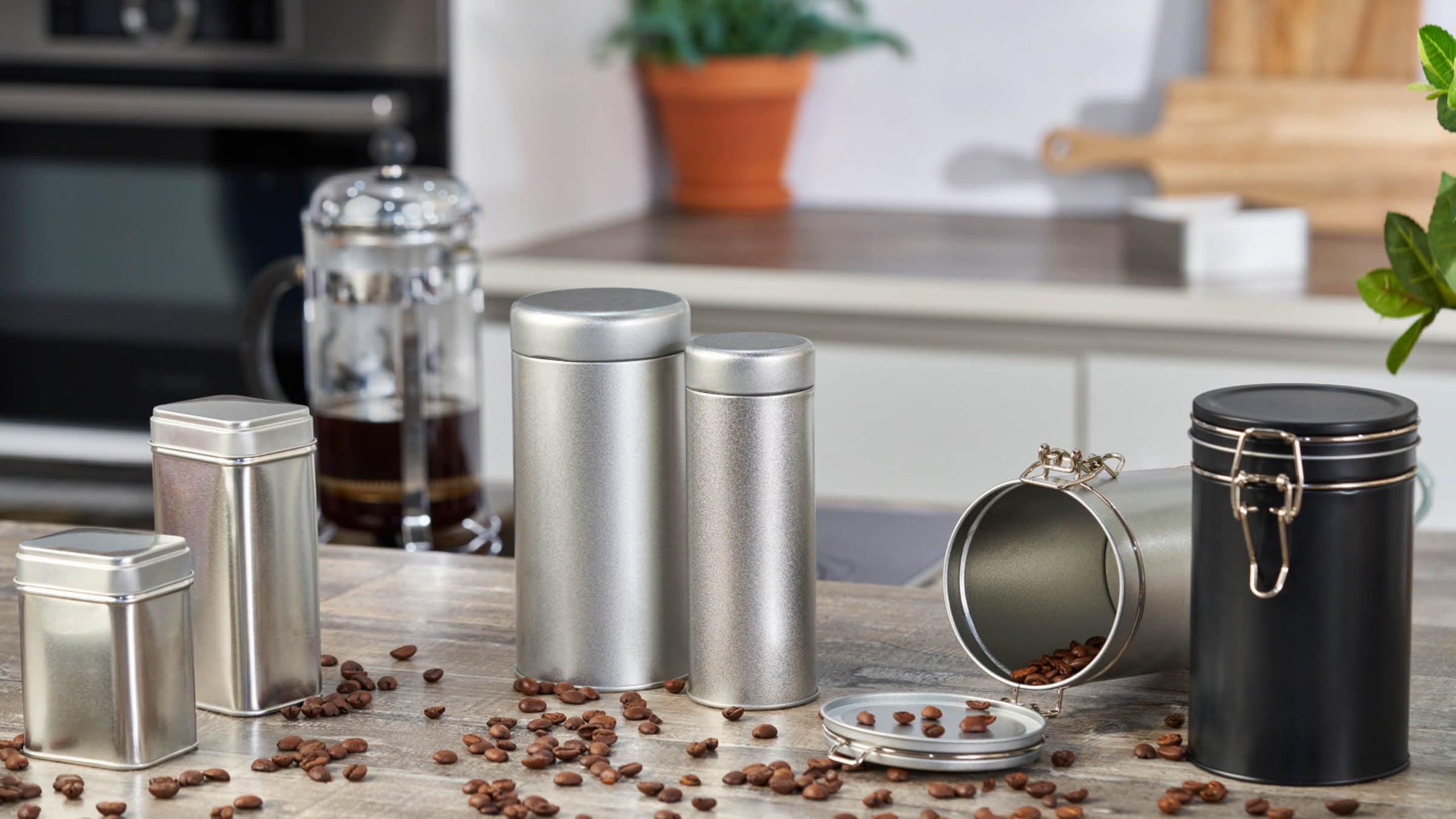 Una gamma di packaging in metallo utilizzati per caffè, spezie, ed erbe aromatiche, in cucina.