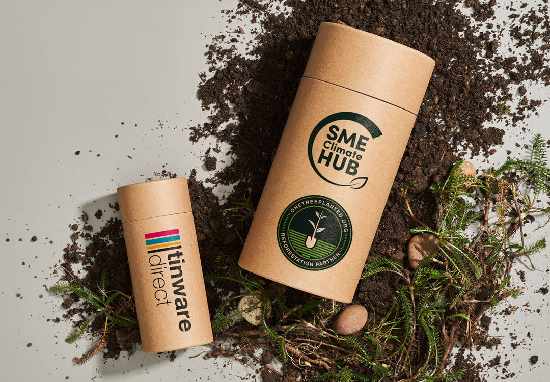 Due tubi in cartone brandizzati Tinware Direct. Un tubo ha il logo One Tree Planted Reforestation Partner e il logo SME Climate Hub.