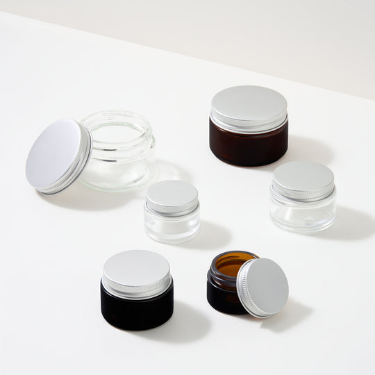 Collezione di vasetti cosmetici in vetro con coperchi a vite